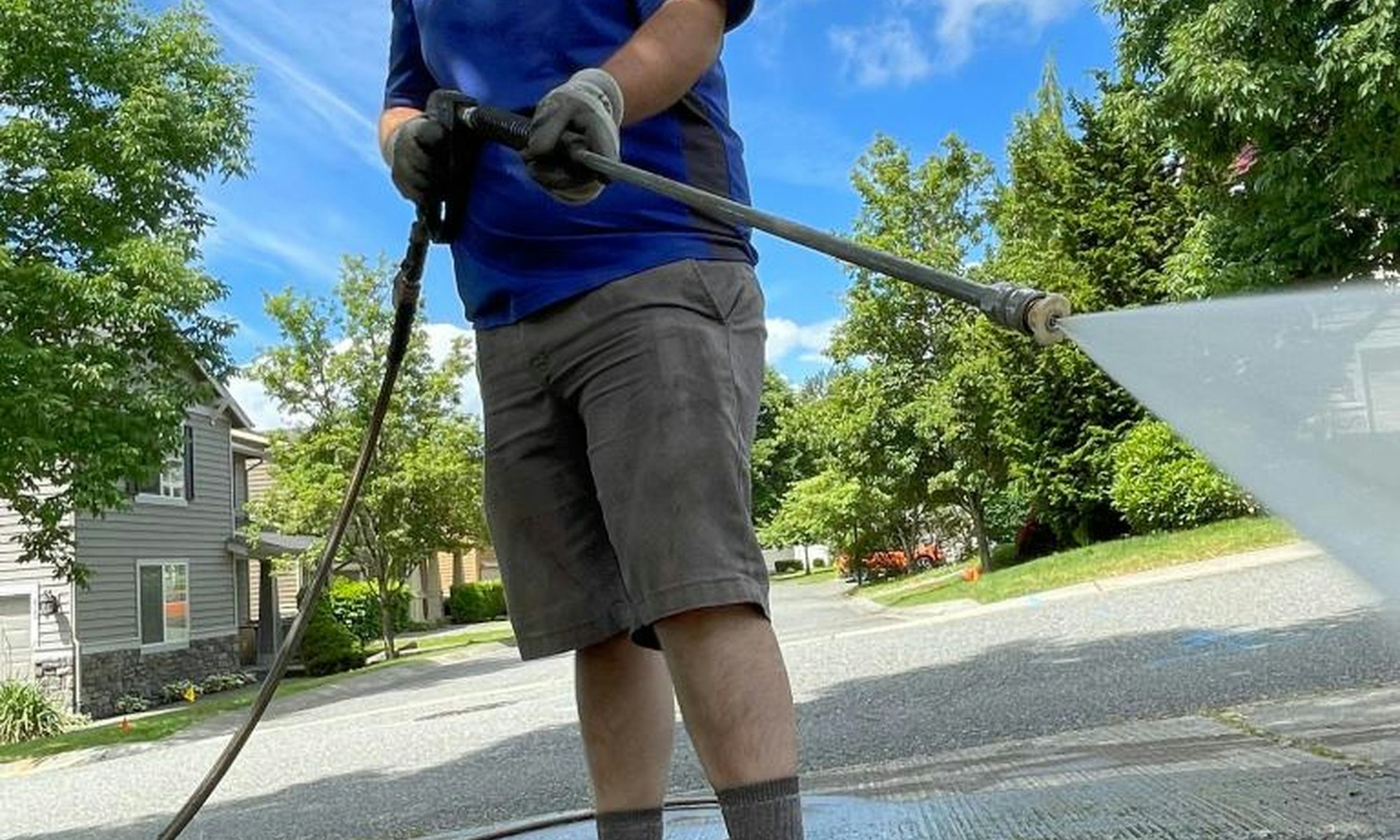 Pressure washing a residential driveway on a clear day